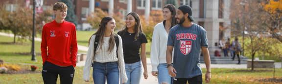 5 students walk across campus